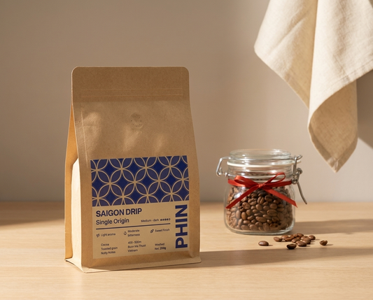 PHIN Saigon Drip coffee bag with degassing valve next to a glass jar of roasted beans
